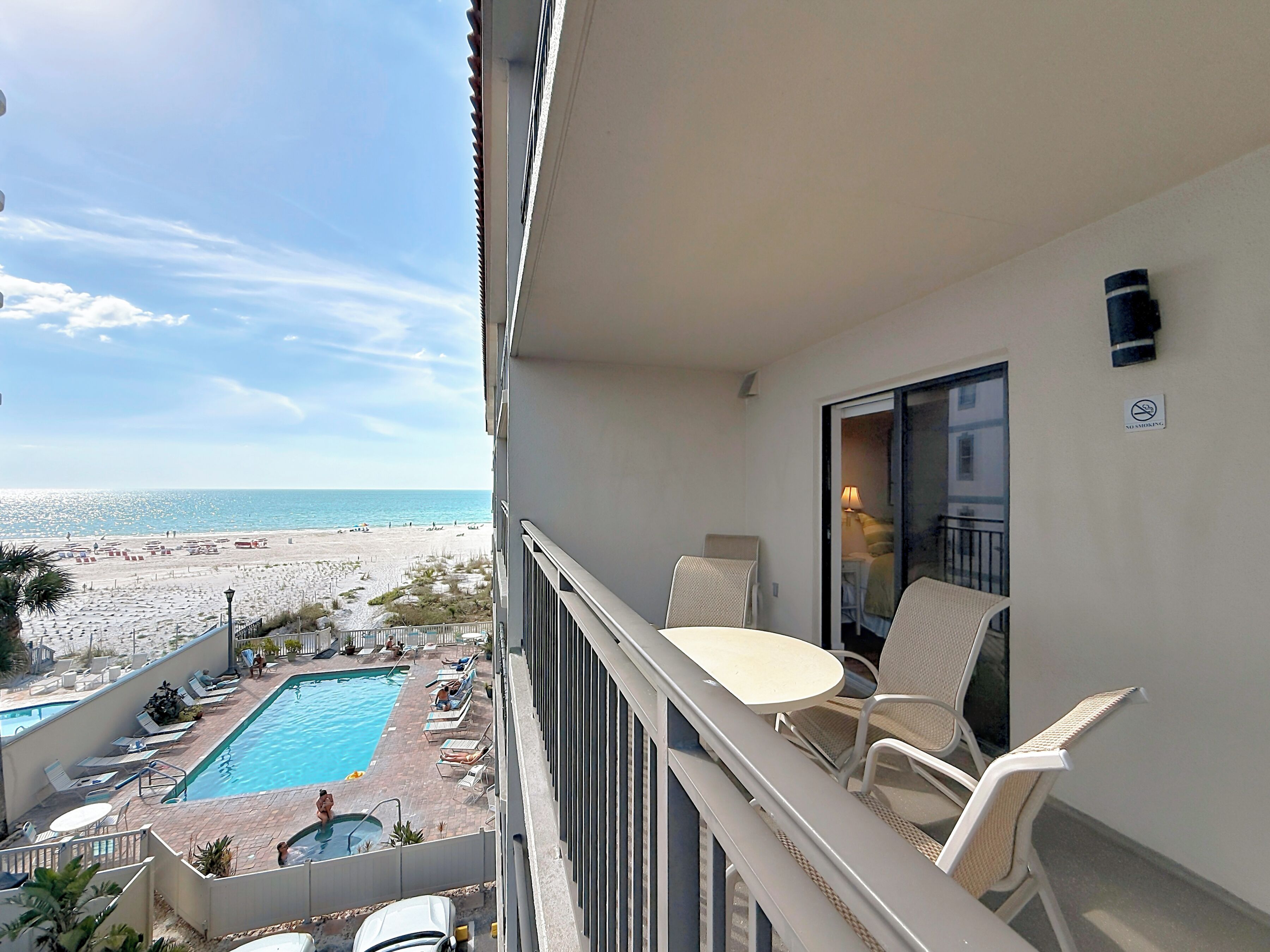 Varanda com piscina, vista para a praia e área de estar.