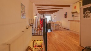 A spacious interior with wooden floors, a staircase, a dining area, and kitchen cabinets. - 14-"La Belle Vue Mer" Cozy Appartement, Centre, Pl (Menton)