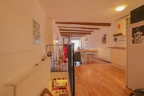 A spacious interior with wooden floors, a staircase, a dining area, and kitchen cabinets.