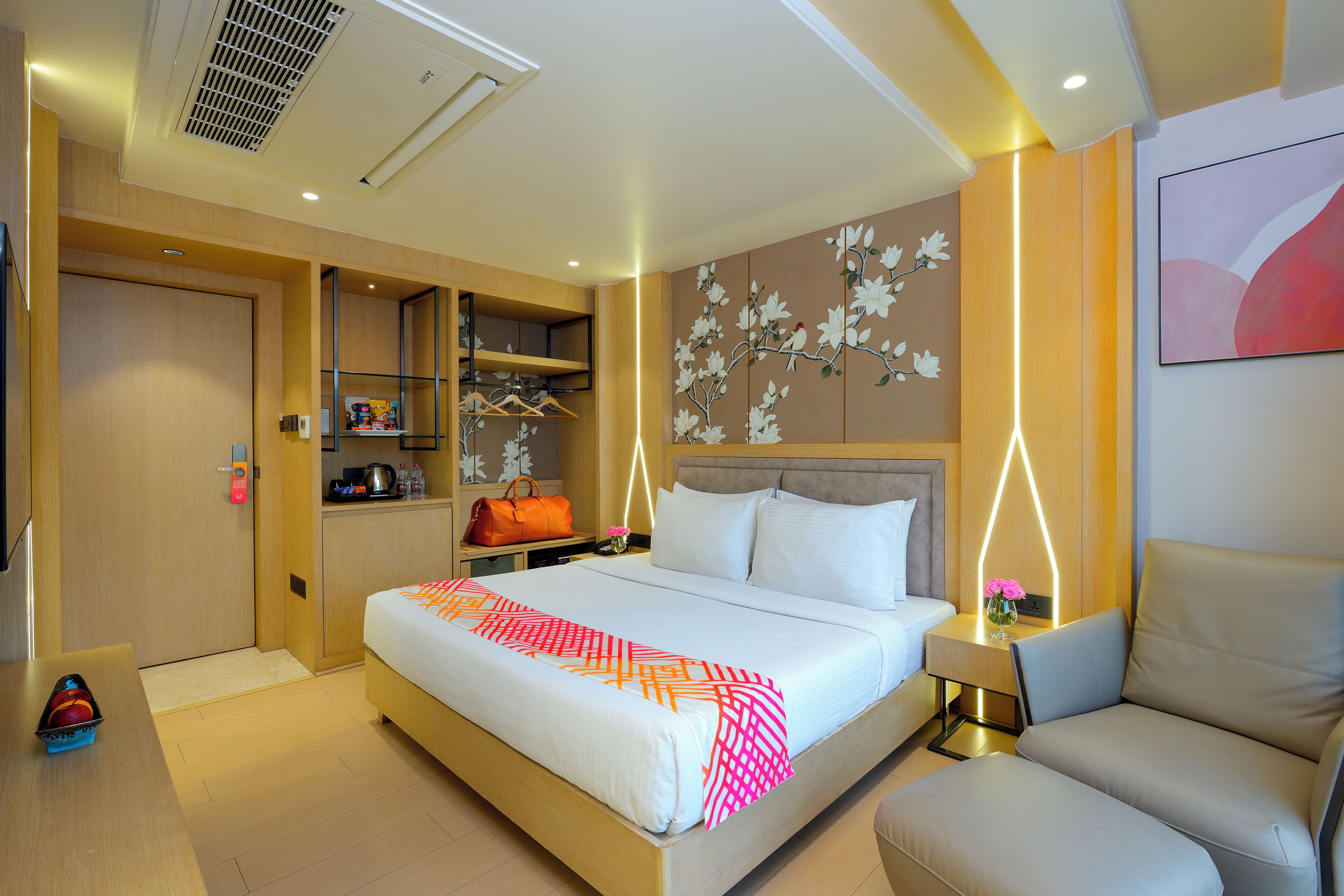 Une chambre d’hôtel avec un grand lit, une table de chevet avec une lampe, une armoire et un tableau au mur.