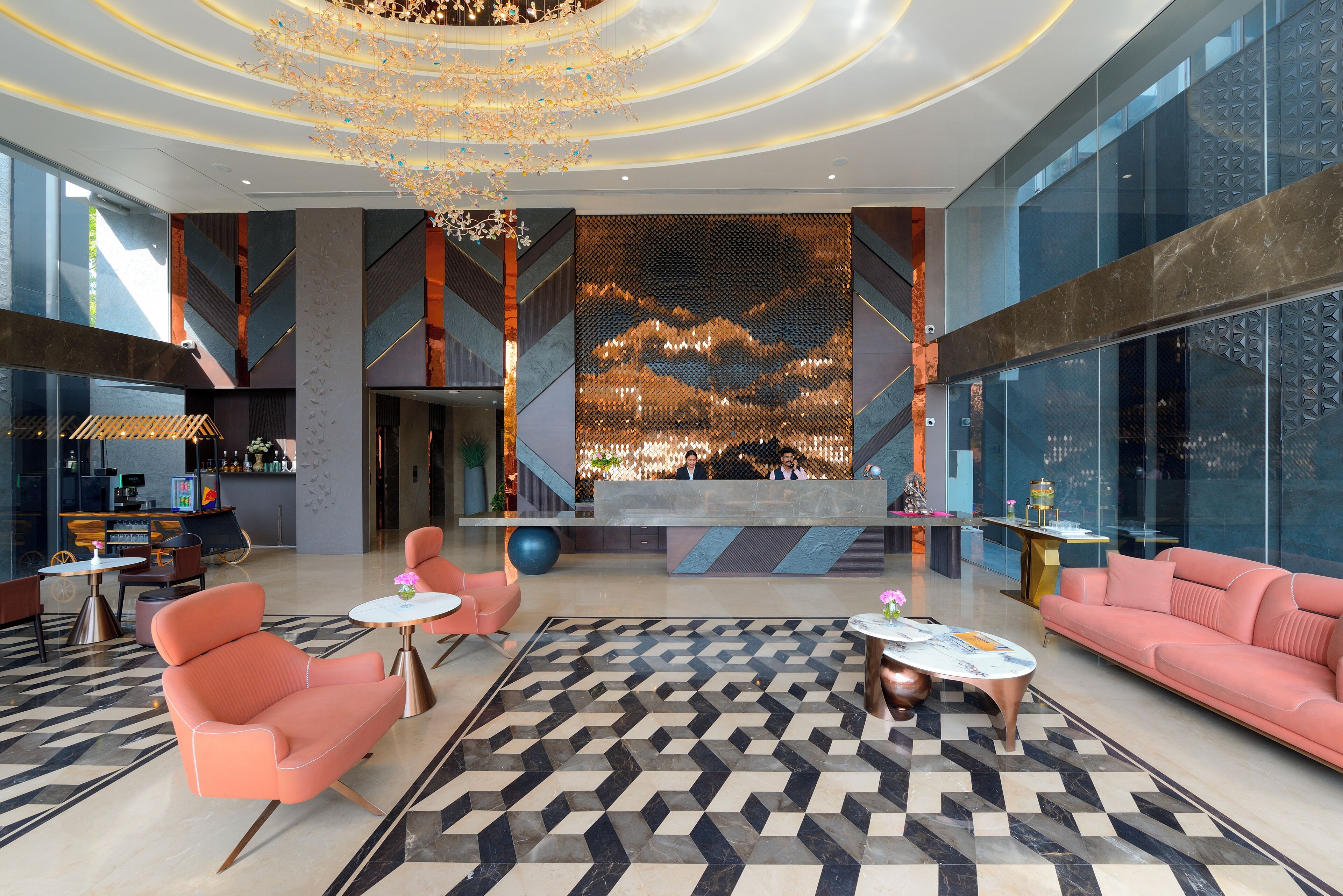 A modern lobby with a reception desk, seating area, and a decorative wall.