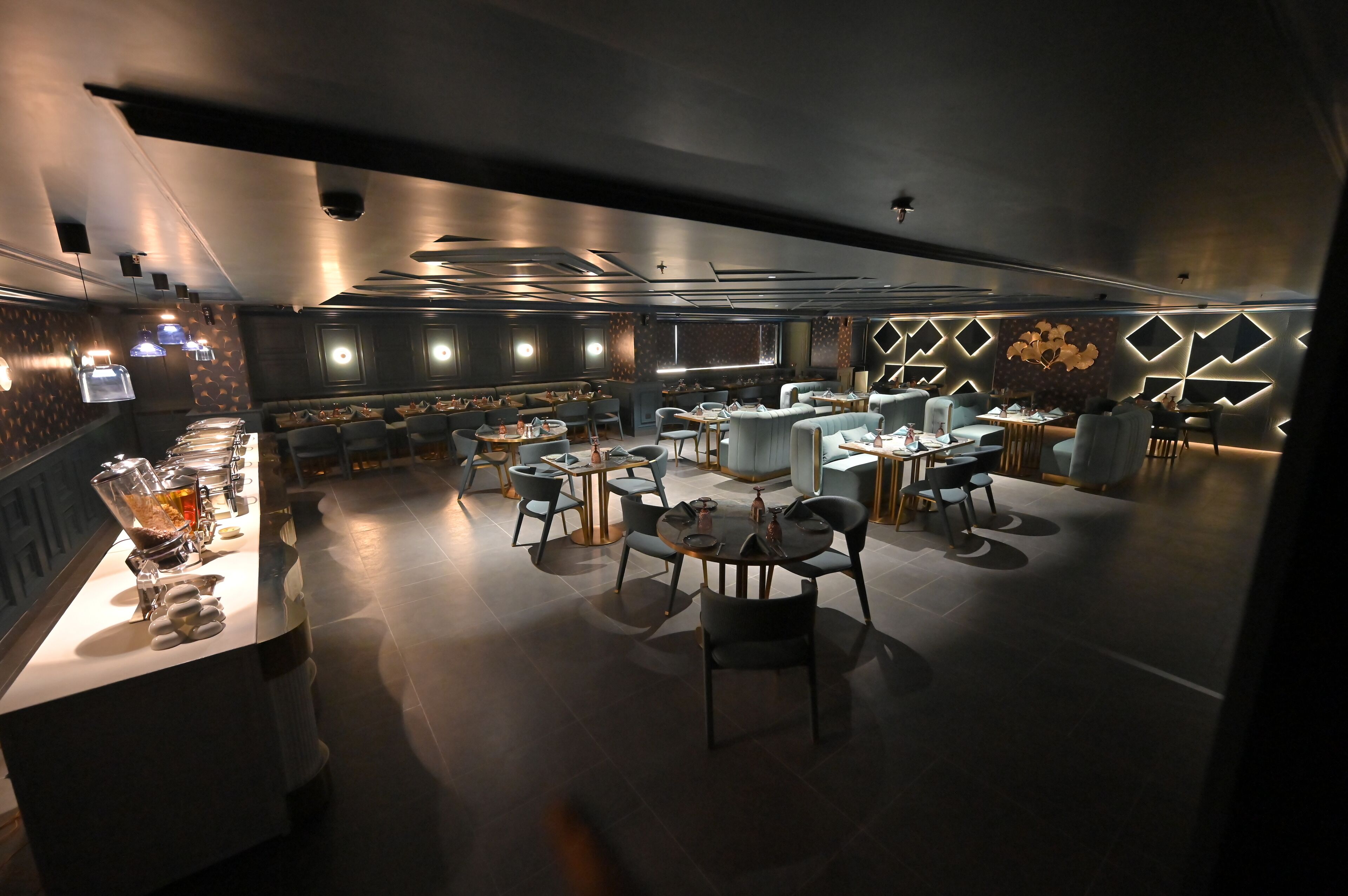Un restaurante moderno con una barra central, diversas opciones de asientos y un diseño de interiores contemporáneo.