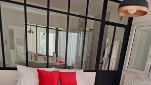 Een moderne slaapkamer met een groot bed, een spiegel en uitzicht op een badkamer.