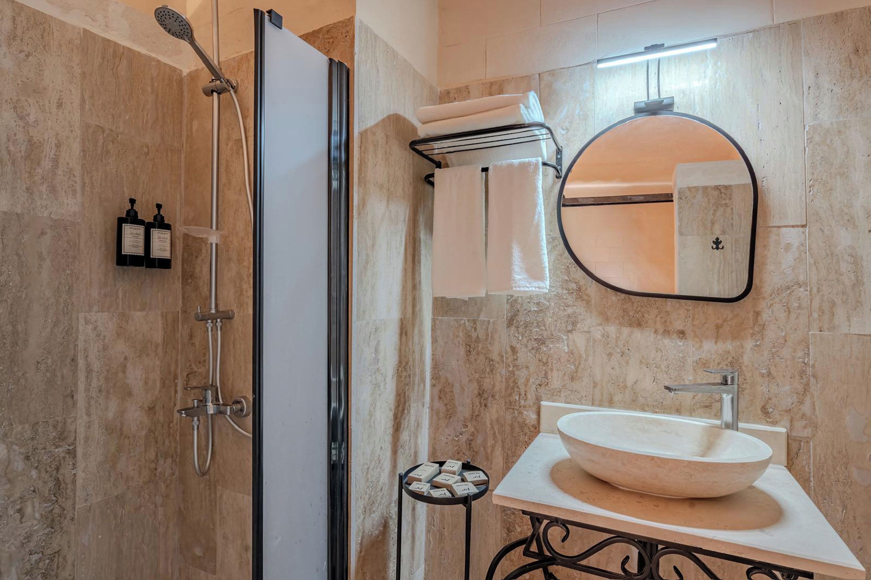 Een moderne badkamer met een douche, een wastafel en een spiegel.