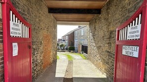 En smal gränd med röda dörrar där det står ”ENDAST FÖR BOENDE” som leder till en byggnad med namnet ”WESTVILLE MEWS”.