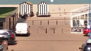 A parking area with a view of the sea, a kiosk, and a few parked cars. - Your bed by the sea (Koksijde)