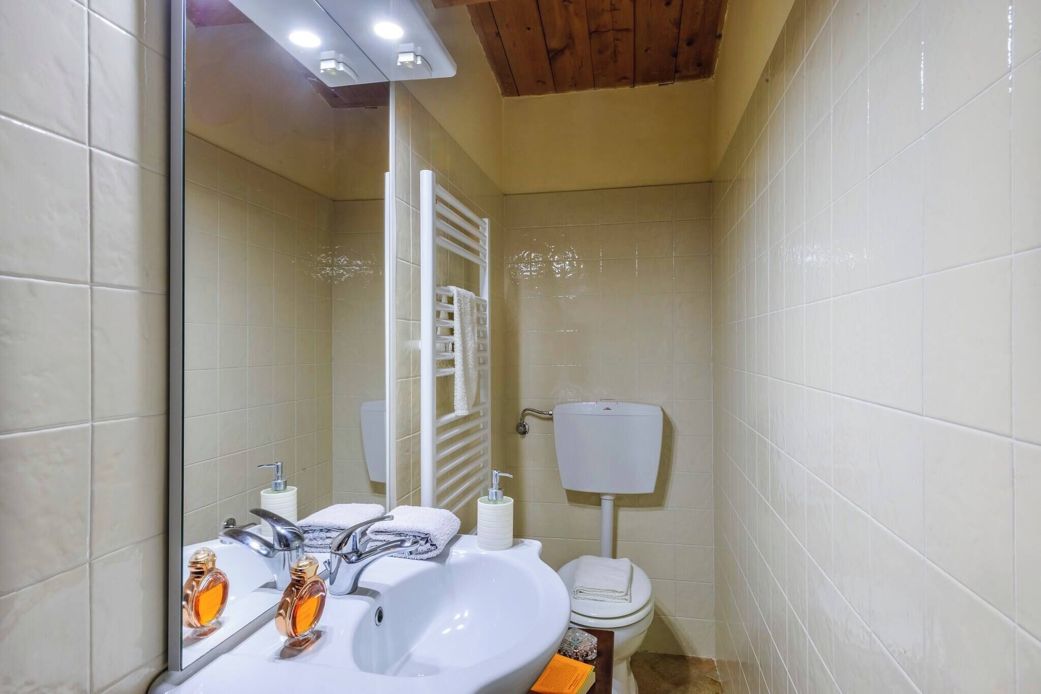 A bathroom with a white sink, mirror, and toilet.