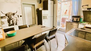 Eine moderne Küche mit Essbereich, einem Kühlschrank und einer Wanduhr.