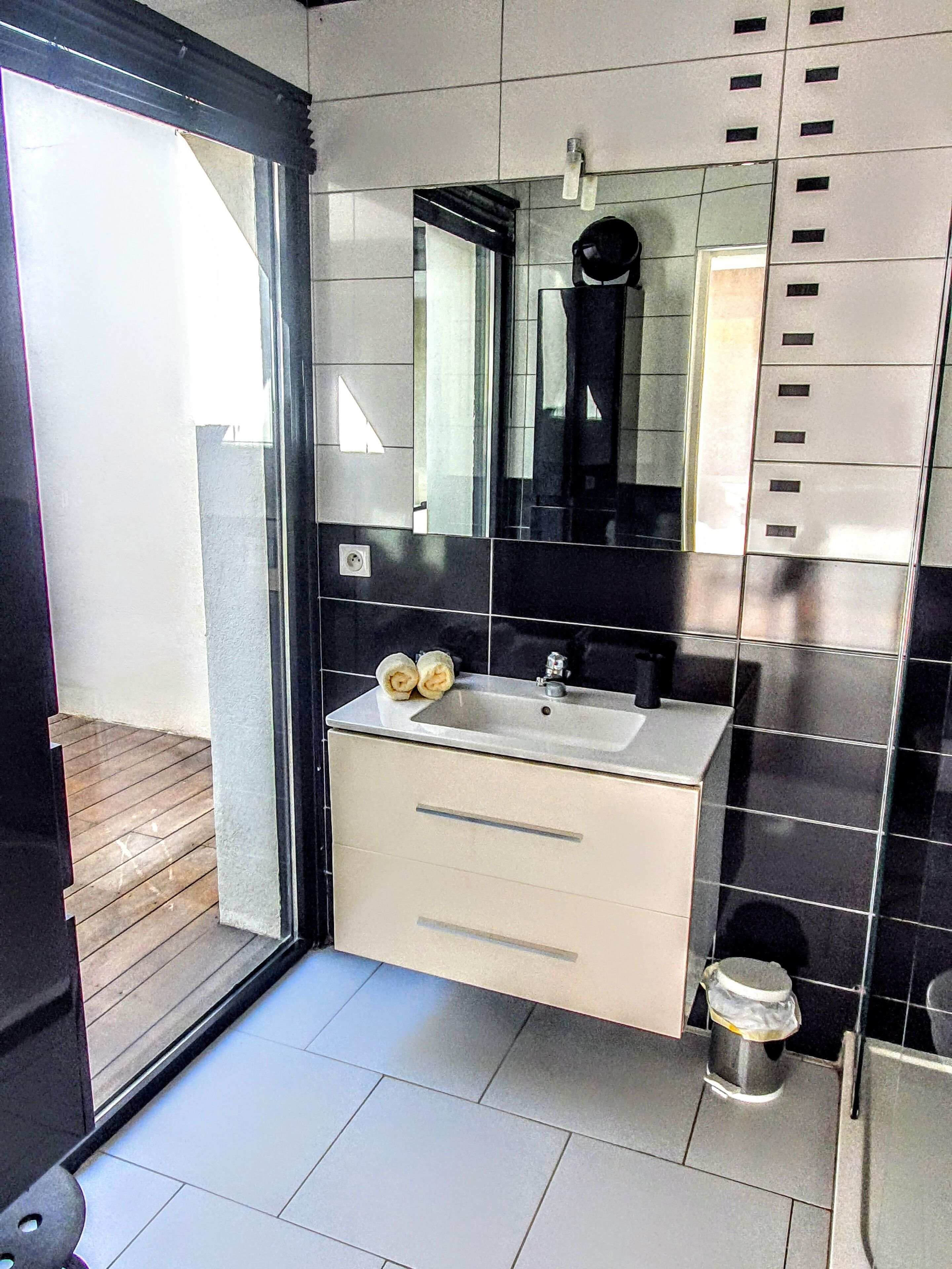 Une salle de bain moderne avec un grand miroir, un lavabo et des toilettes.