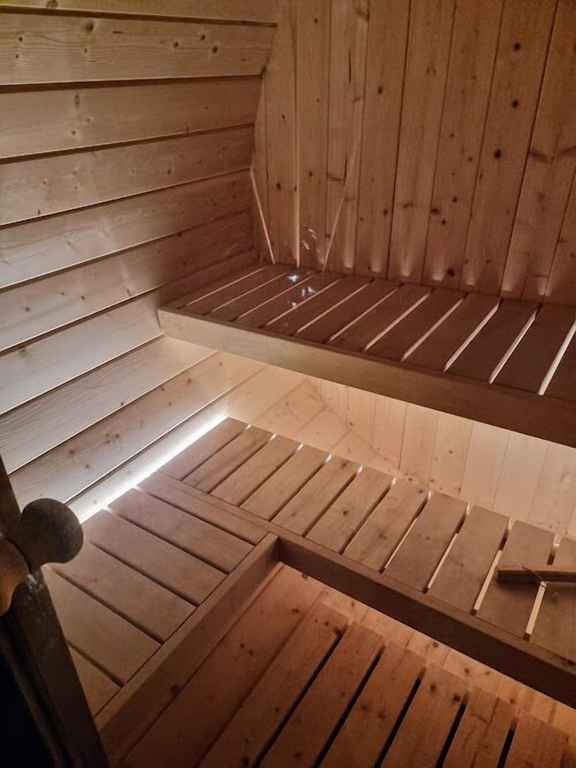 Een houten blokhut van binnen, met een schuine kap en een houten balkstructuur in het midden.