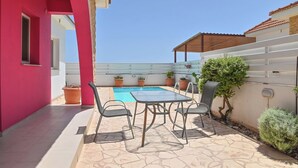 Une terrasse sur le toit avec une piscine, des plantes en pot et du mobilier d’extérieur.