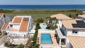 Un quartier résidentiel doté d’une piscine, de panneaux solaires et offrant une vue sur la mer.