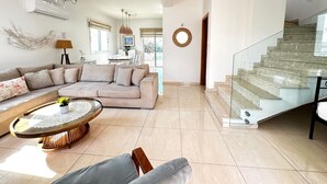 Un vaste espace de vie doté d’un escalier moderne, d’un coin repas et offrant une vue sur l’extérieur.