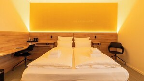 A hotel room with two beds, a desk, a chair, and a coffee machine. - BDB-Kulturhotel (Staufen im Breisgau)