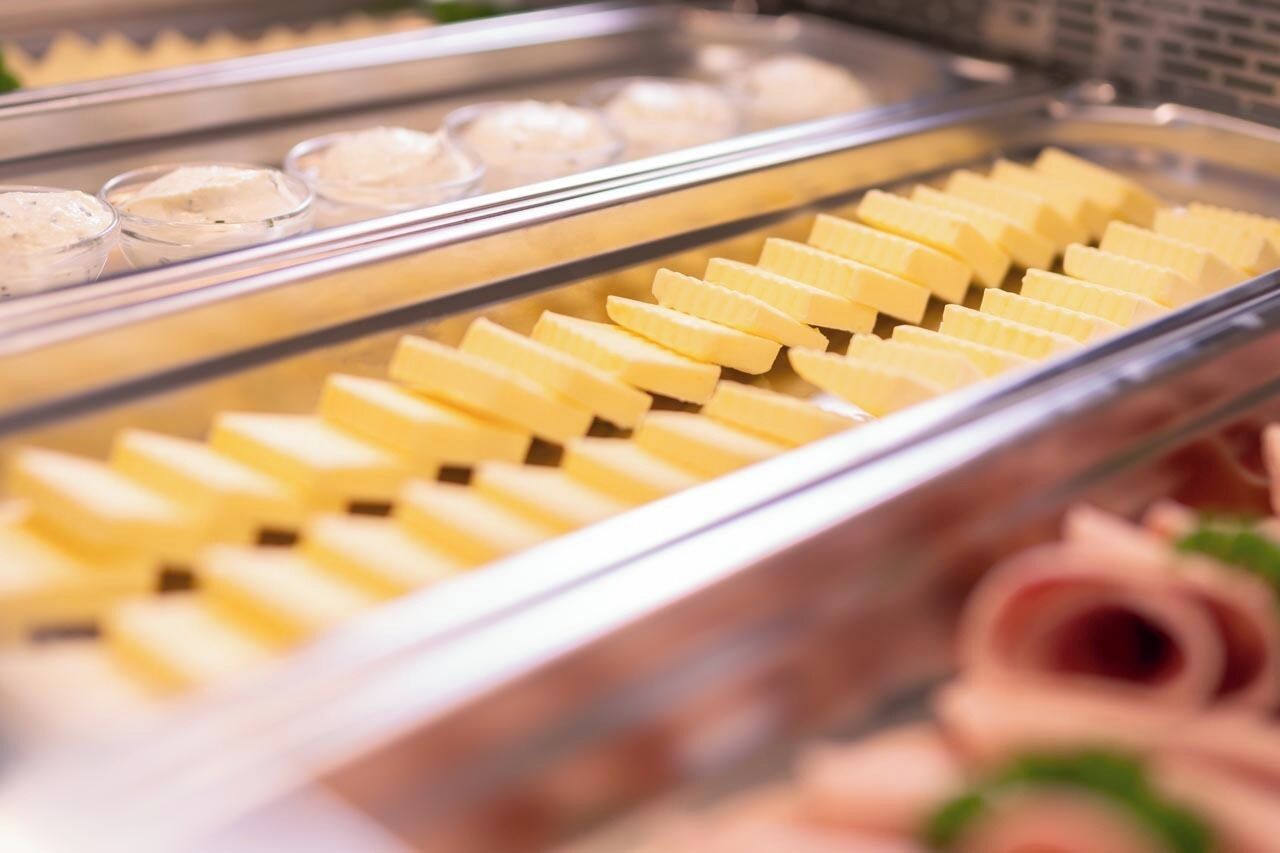A buffet with various food items including butter cubes and a selection of dips.