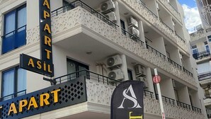 Un edificio de varios pisos con balcones y unidades de aire acondicionado.