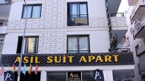 Un edificio con un letrero que dice "ASIL SUIT APART" y banderas.