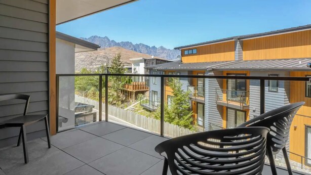 A balcony with a view of neighboring houses and mountains. - Grand Alpine Villa - 4 bedrooms (Queenstown)