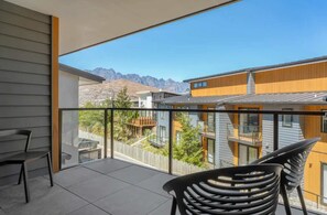 Un balcon avec vue sur les maisons voisines et les montagnes.