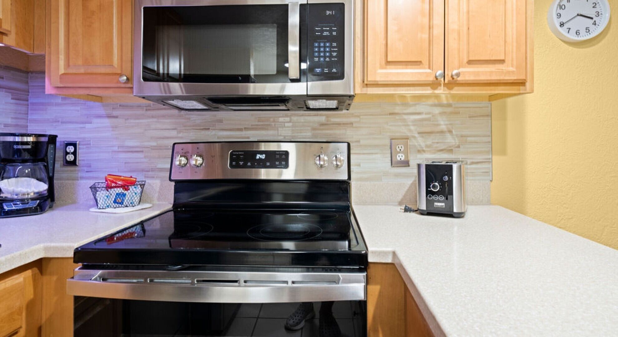 A kitchen with a stainless steel microwave, oven, and toaster.