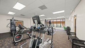 A gym with cardio machines, weight stations, and a bench. - Park Thrills + Poolside Vibes = Vacation Goals! (Kissimmee)
