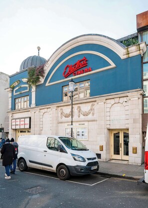 A building with a blue facade and a sign that reads 'Electric Cinema.'