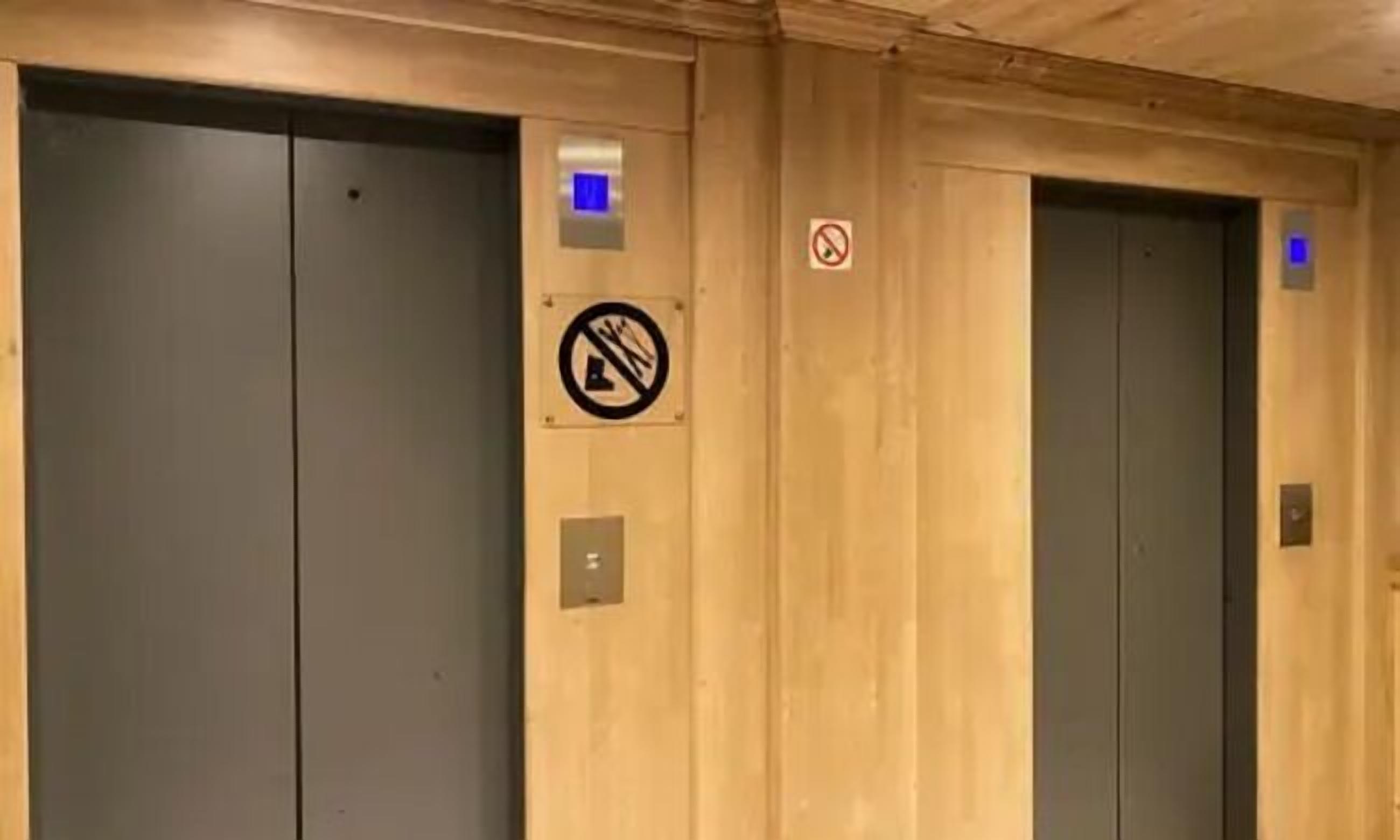 An elevator with a no-smoking sign and a blue light indicator.