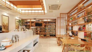 Um interior moderno com cozinha, área de refeições e uma grande estante.