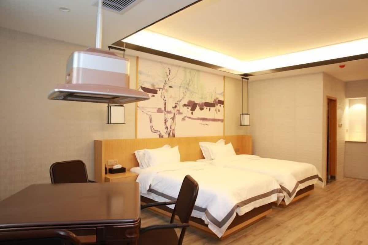 Ein Hotelzimmer mit Bett, Nachttisch, Stuhl und einem Bild an der Wand.