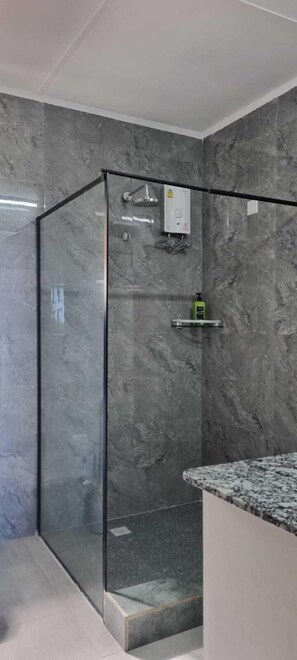 Deluxe eenpersoonskamer | Badkamer | Een douche, een regendouche, een haardroger, handdoeken
