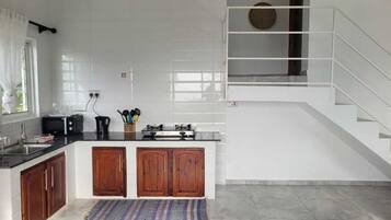 A modern kitchen with a central island, wooden cabinets, and a stainless steel stove.
