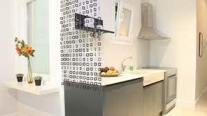 Una cocina moderna con encimera blanca, armarios grises y un salpicadero con diseño.