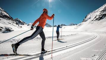 Deux skieurs sur une piste enneigée, sous un ciel dégagé.