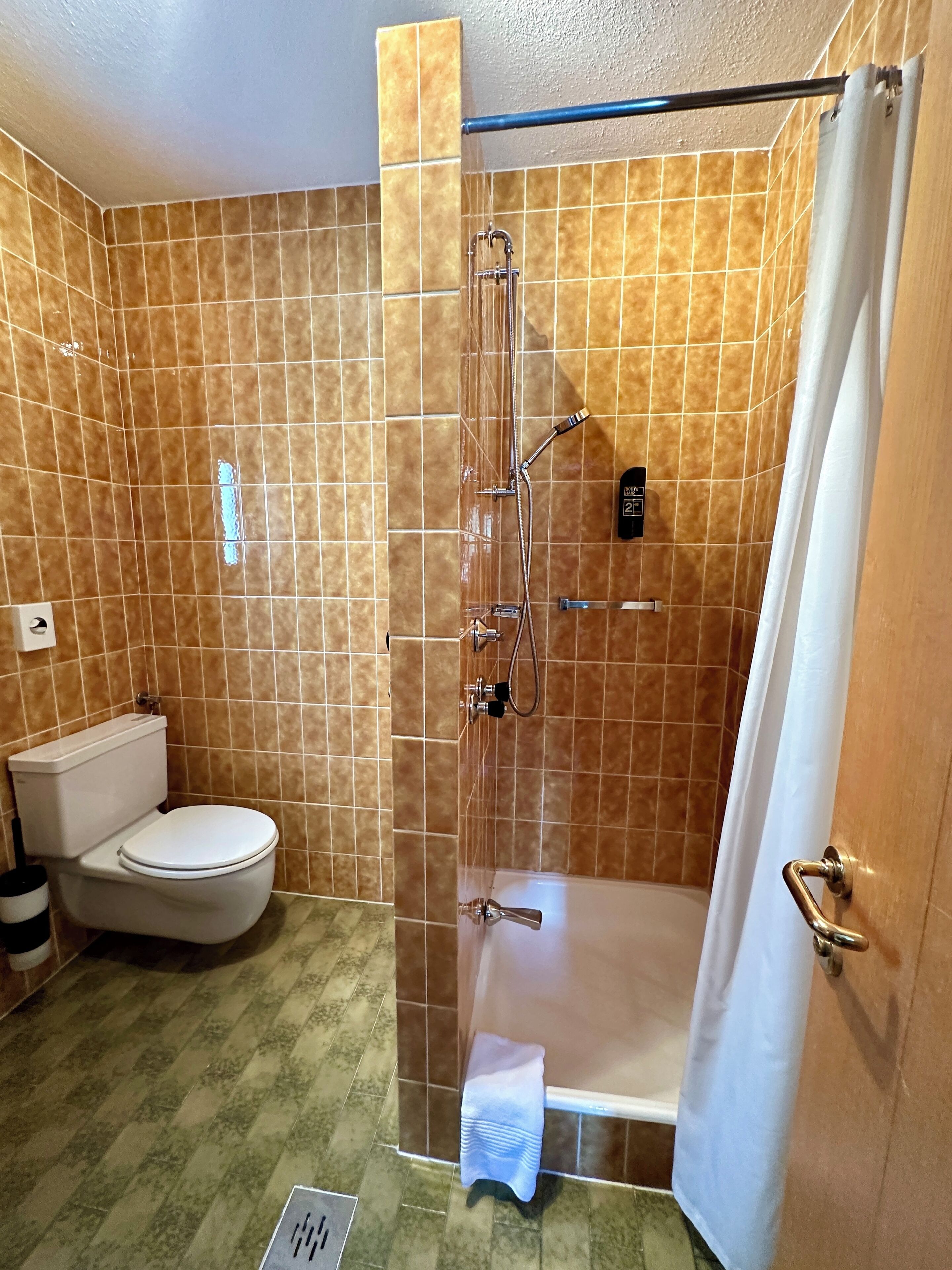 Un baño con ducha envuelta en vidrio, inodoro y bañera.