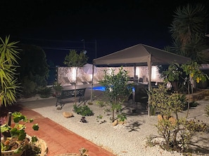 An outdoor patio area with a covered seating area, a pool, and various plants. - Apartment 2-Villa Augusta-del-Sol  (Fontane Bianche)