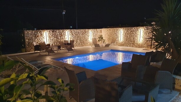 An outdoor swimming pool with stone walls and lounge chairs. - Apartment 2-Villa Augusta-del-Sol  (Fontane Bianche)