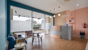 Een moderne receptie met een 'cove' bord, zitgedeelte en uitzicht door grote ramen.