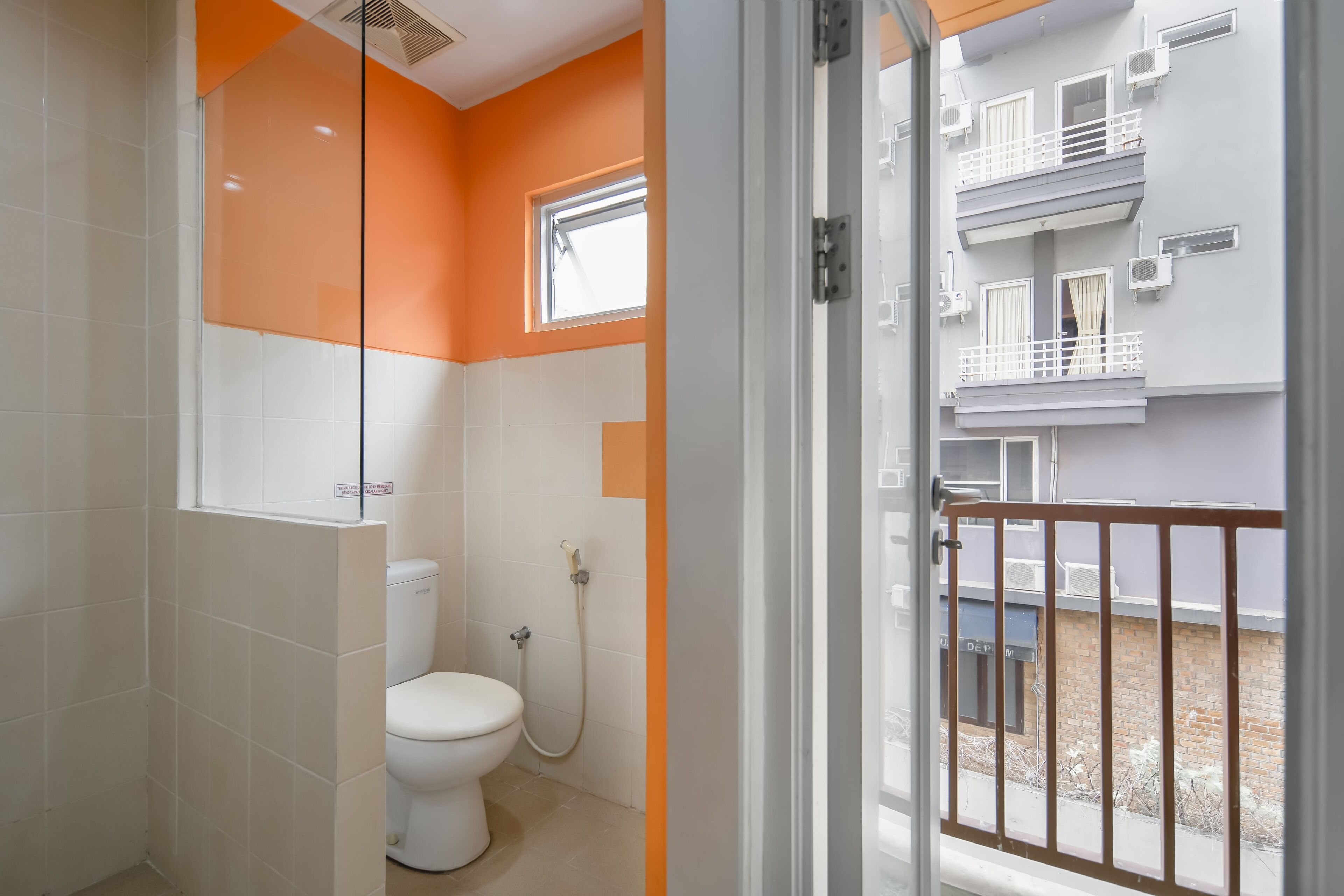 Un baño con inodoro, ducha y ventana.