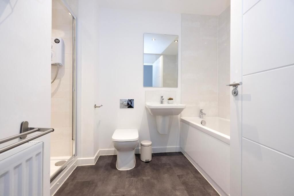 A compact, modern bathroom with a toilet, sink, and bathtub.
