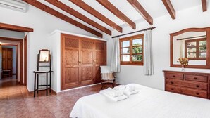 A bedroom with a large bed, wooden wardrobe, and a dresser. - Villa Oliveres, Beautiful villa in the countryside near Pollensa (Pollença)