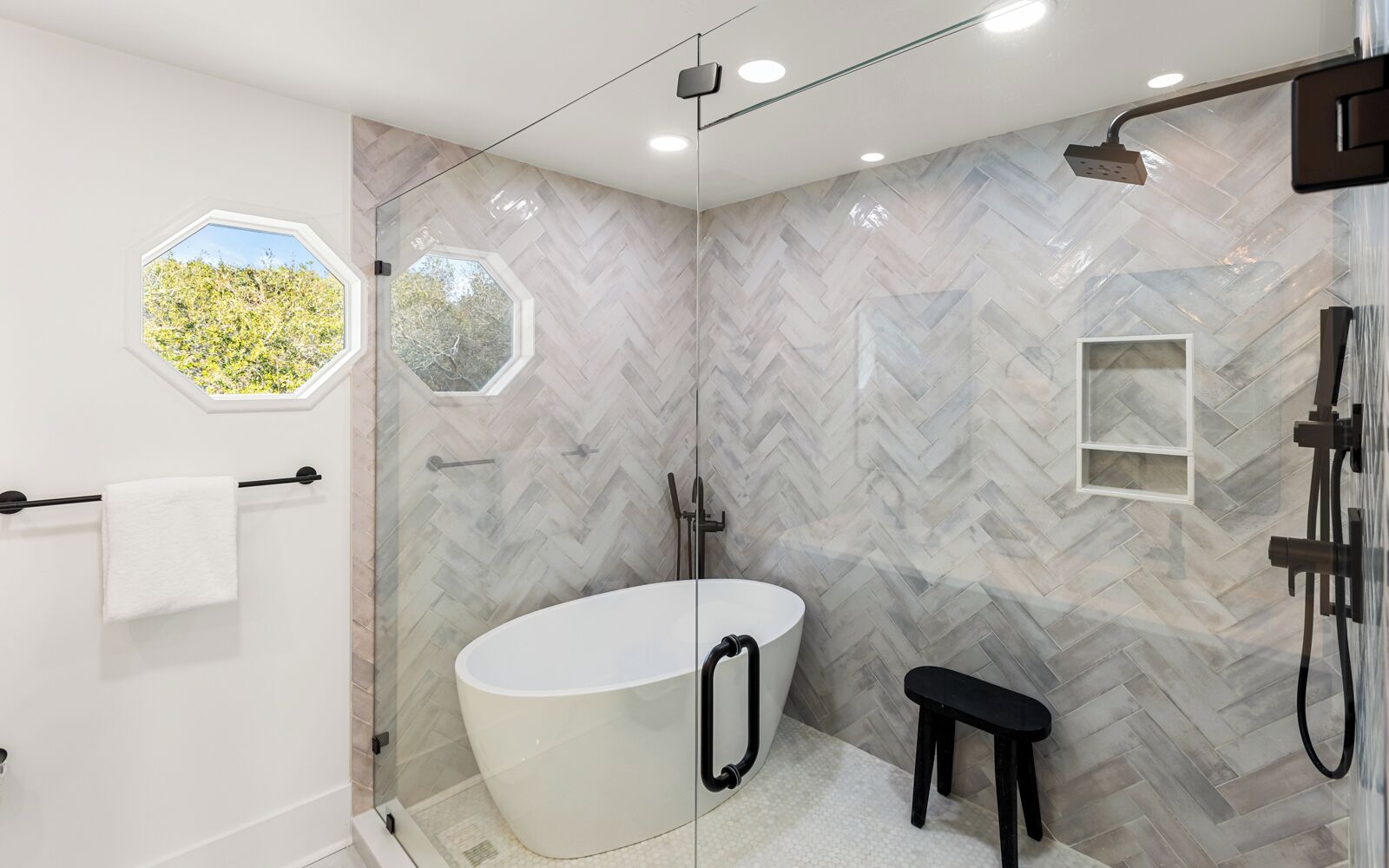 A modern bathroom with a freestanding bathtub, a shower, and a glass-enclosed shower area.