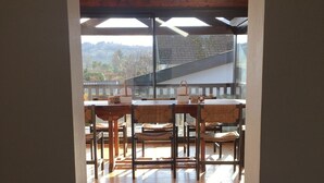 Una escalera conduce a un comedor con suelo de madera y sillas.