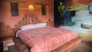 A bedroom with a wooden bed, a mural on the wall, and a sunset depicted above the bed. - Viewpoint of the waters (Sesquilé)