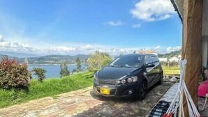 A hammock on a porch overlooking a scenic view with a car parked nearby. - Viewpoint of the waters (Sesquilé)