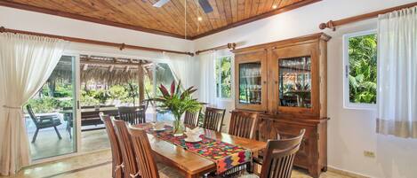 A dining area with a wooden table, chairs, and a ceiling fan.