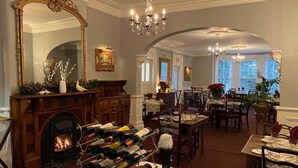 A dining area with a fireplace, wine rack, and chandeliers.
