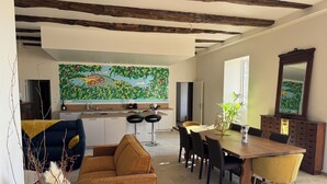 A modern kitchen with a large island, bar stools, and a dining table with chairs.