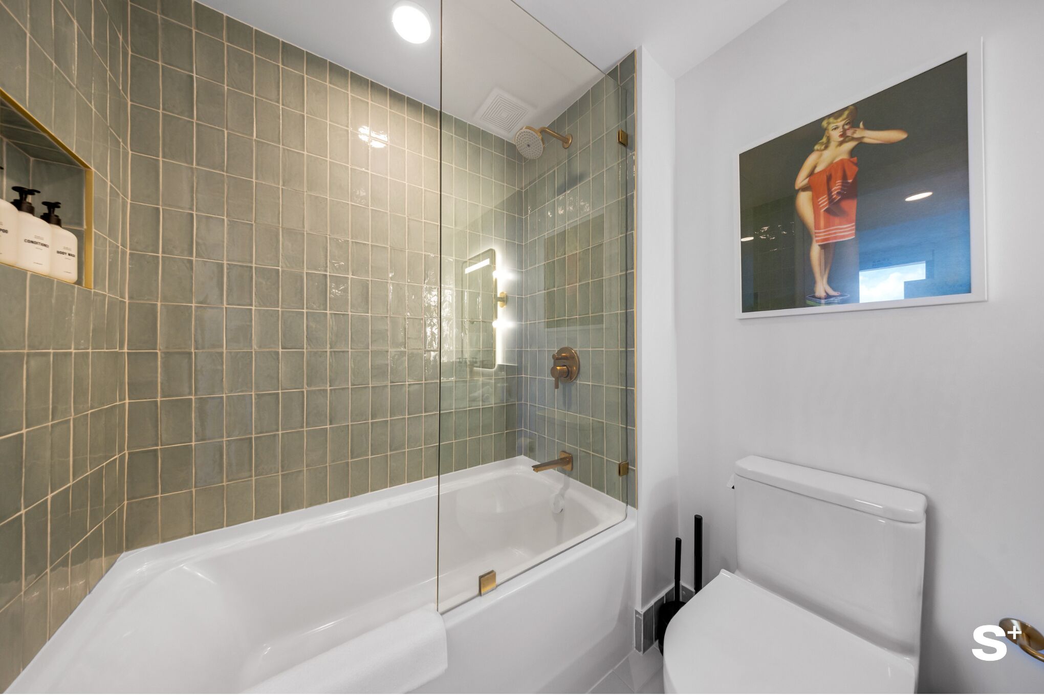 A modern bathroom with a glass-enclosed shower, a white bathtub, and a toilet.