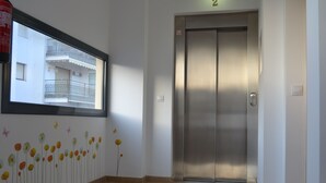 Un ascensor moderno y limpio con detalles metálicos y un letrero con el número 2.