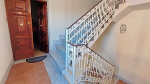 Una escalera con barandillas blancas y una puerta de madera.